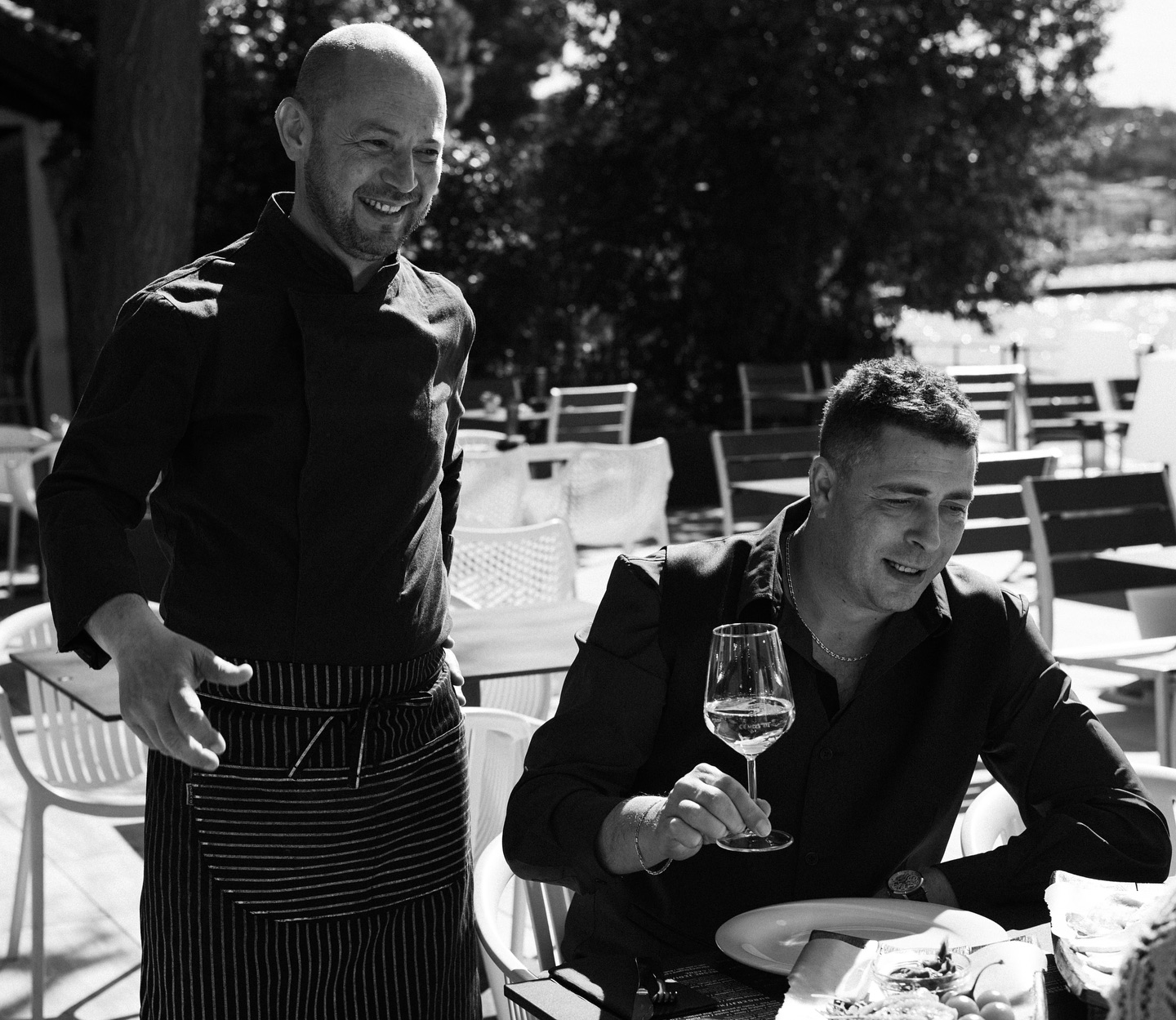 Chef and guest enjoying wine on the seaside terrace